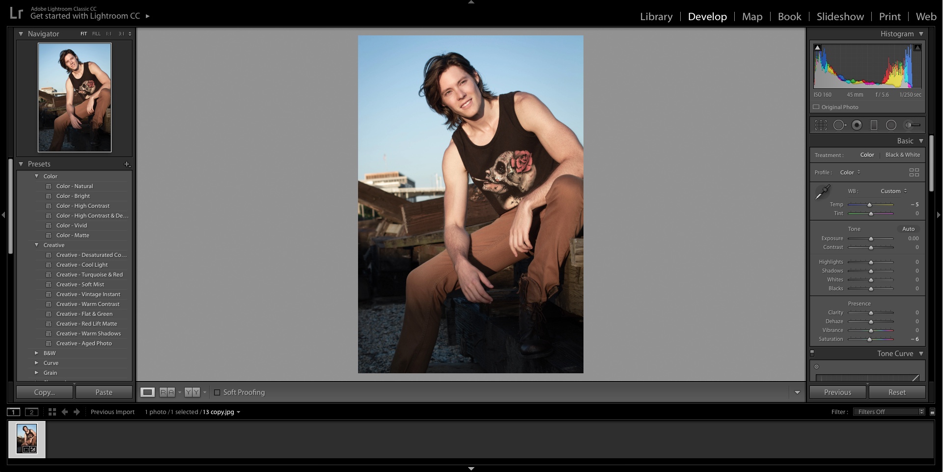 A screenshot of Adobe Lightroom software while editing a photograph of a young male model in a tank top with long brown hair